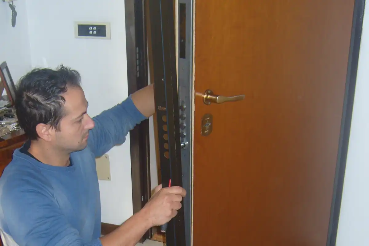 Fabbro smonta l’intelaiatura di una porta blindata a Torino