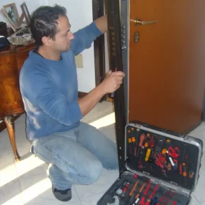 Fabbro sostituisce la serratura di una porta blindata.